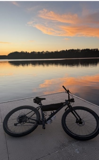 A bike on a dock at sunset on a Northwoods lake.